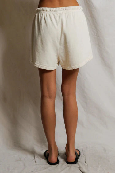 Person wearing white shorts against a plain background