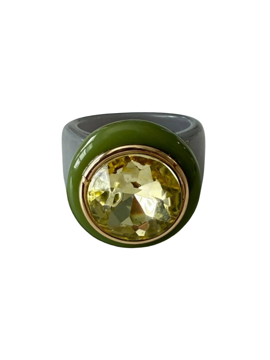 Ring with a green band and yellow gemstone on a white background