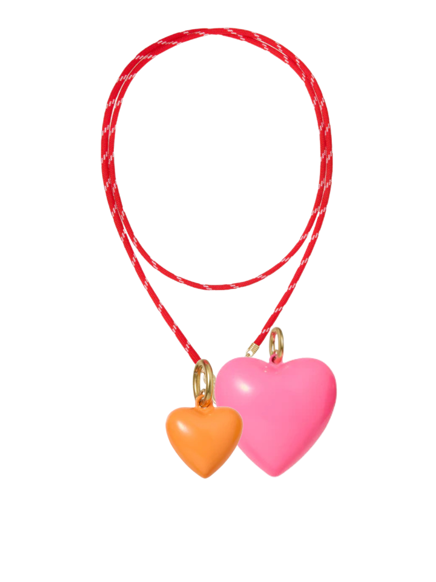 Two heart-shaped charms on a red string with a white background