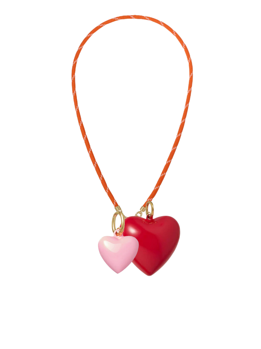 Necklace with pink and red heart pendants on an orange cord against a white background