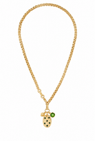 A gold chain necklace featuring a ladybug charm with black spots and a small green gemstone accent, displayed against a solid white background.