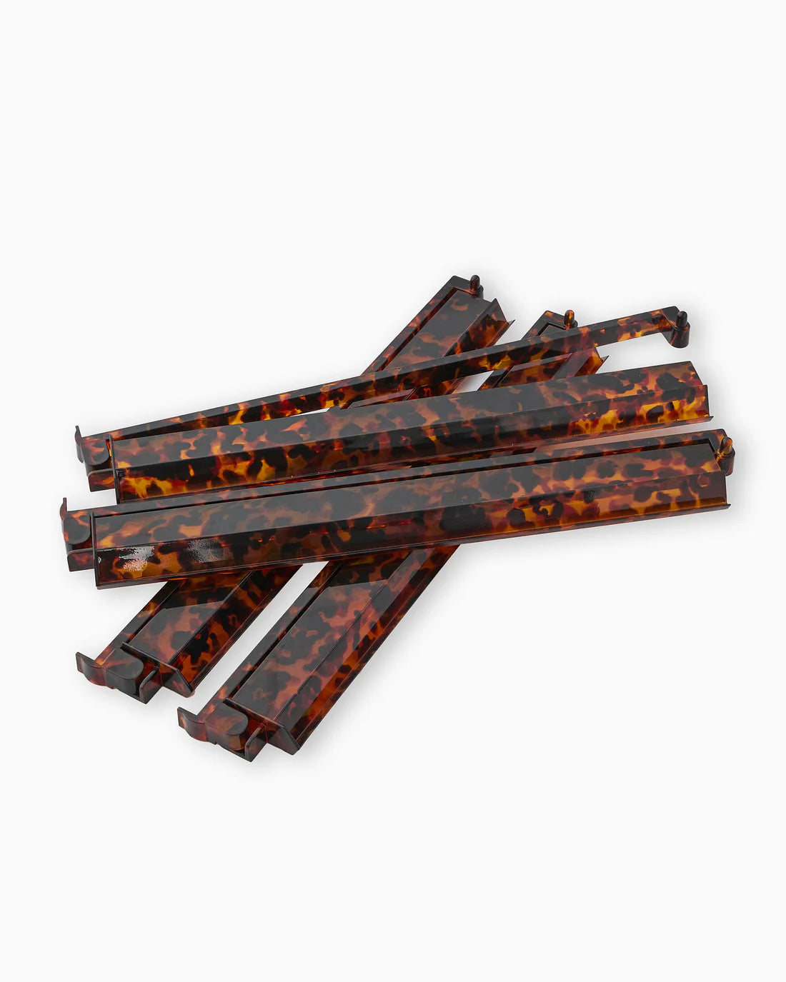 Set of tortoiseshell-patterned plastic straws on a white background