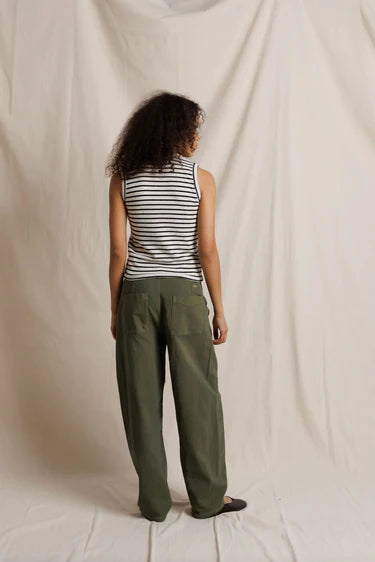 Person wearing a striped tank top and green cargo pants against a plain background