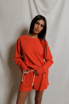 Woman wearing a red outfit against a plain background