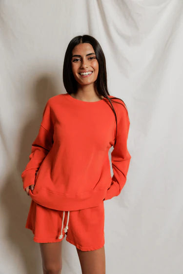 Woman wearing a red outfit against a plain background