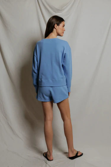 Person wearing a blue outfit standing against a plain background