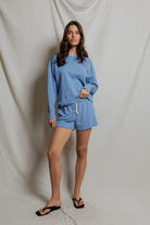 Woman wearing a blue outfit against a plain background