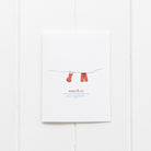 Notebook with red socks on a string design and 'Ramus & Co' branding on a white background