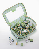Green decorative tiles with patterns in a matching case on a white background