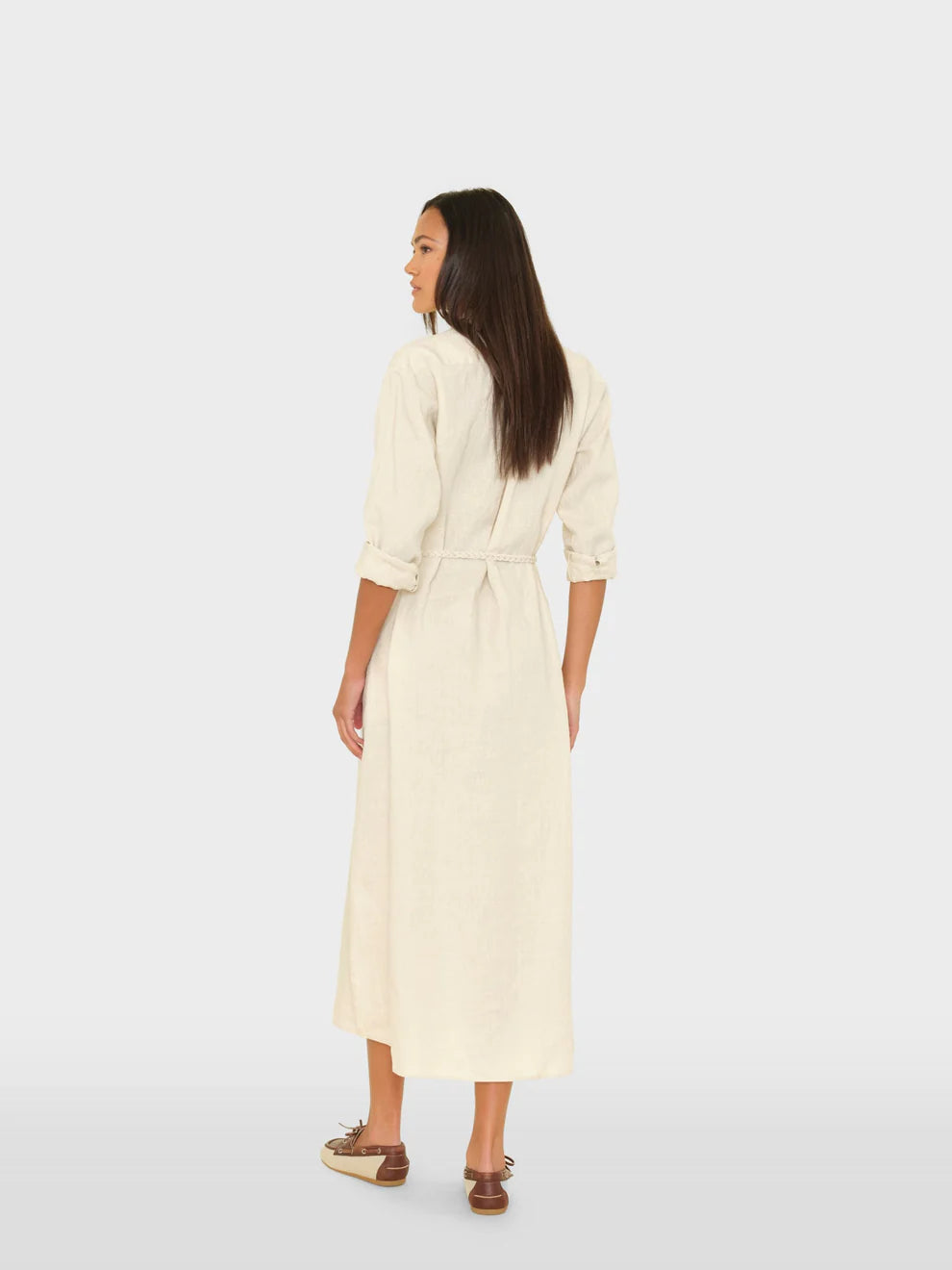 Woman wearing a cream-colored dress on a white background