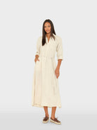 Woman wearing a beige dress on a white background