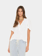 Woman wearing a white top and striped pants on a white background