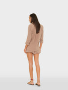 Woman wearing a beige dress on a white background