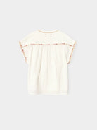 White blouse with floral details on a light gray background
