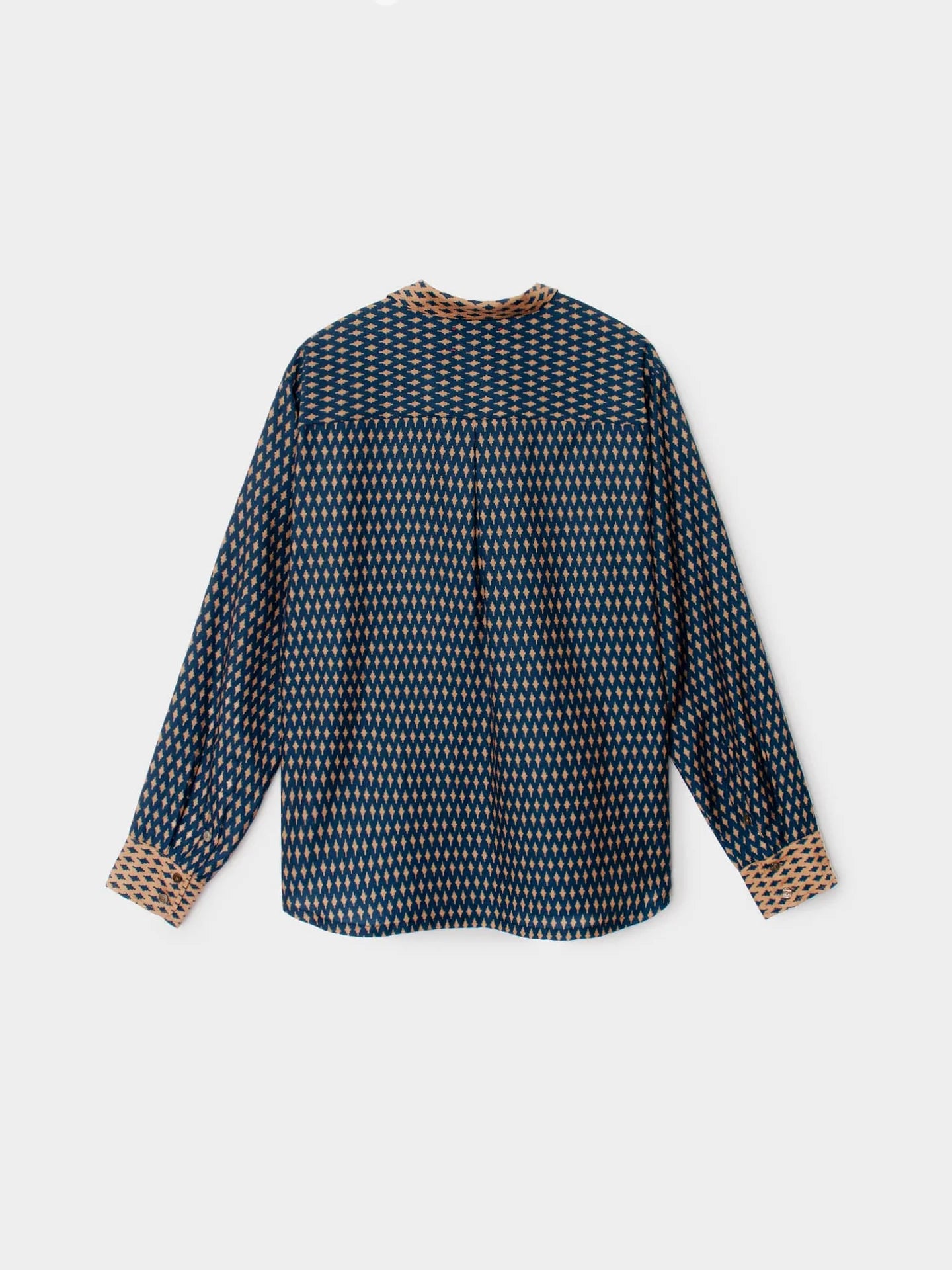 A long-sleeve button-up shirt with a dark navy blue and beige geometric pattern, featuring contrasting beige patterned cuffs and collar trim, shown against a light gray background.