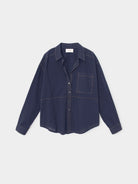 A dark navy blue long-sleeve button-up shirt with a collar, a chest pocket, and subtle contrast stitching, displayed flat against a light gray background.