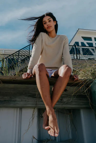 Woman sitting on a wooden structure with a scenic background