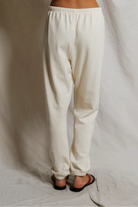 White pants worn by a person on a plain background