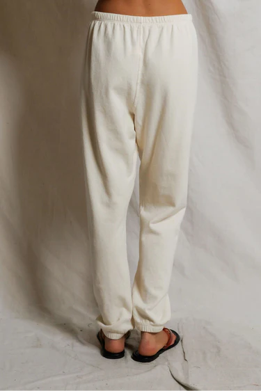 White pants worn by a person on a plain background