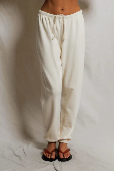 White pants worn by a person on a plain background