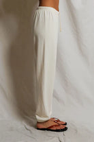 White pants worn by a person on a plain background